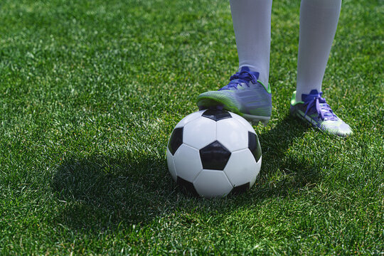 Feet of soccer player step on soccer ball for kick off in stadium