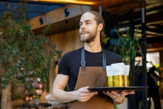 Confident server holding tray with napkins