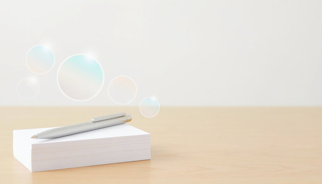 Silver pen resting on a stack of white business cards on a wooden desk with magical floating iridescent bubbles, clean minimalist workspace aesthetic, soft bright lighting