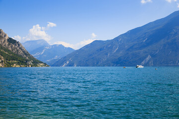 Obraz premium Lake Garda in Italy with blue water and mountains in background. The most famous tourist destination. Travel and tourism concept 