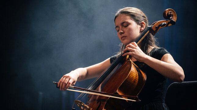 A girl plays the cello in the conservatory hall. Playing the cello during a rehearsal, a solo concert, a talented young cellist