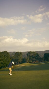 4K vertical golf video on a man hitting a golfing ball with a club on a course in Vermont, New England, USA.