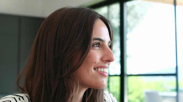 Profile of a serene young woman breathing deeply with her eyes closed, feeling peaceful and hopeful. Her face shows contentment and tranquility as she enjoys a quiet moment of mindfulness at home