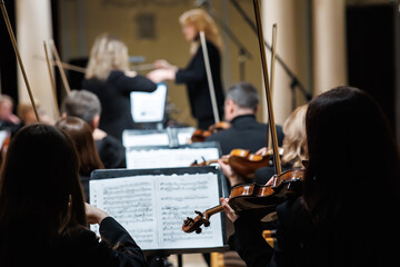 Symphony orchestra musician playing violin close up on stage © Ivan