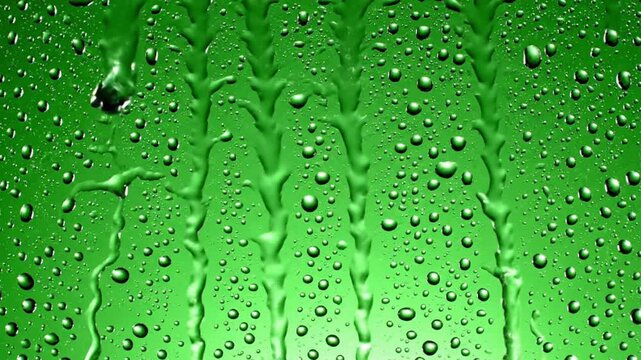 Rain falls on window glass while drops create patterns and sounds in the background during a rainy day