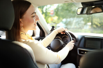 Woman behind steering wheel of modern car