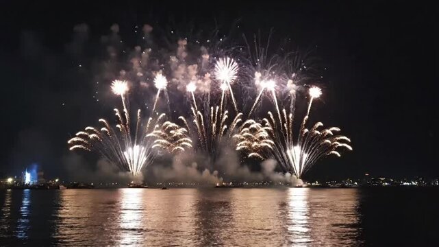 Enjoy fireworks display over water with colorful explosions in the night sky