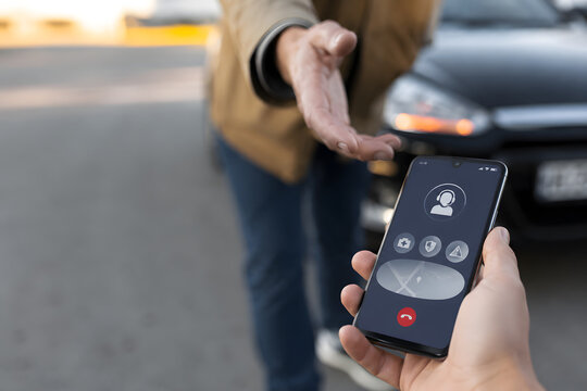 Photorealistic smartphone displaying an emergency assistance app, with a hand reaching toward the device. Modern support access concept, roadside emergency scenario, copy space.
