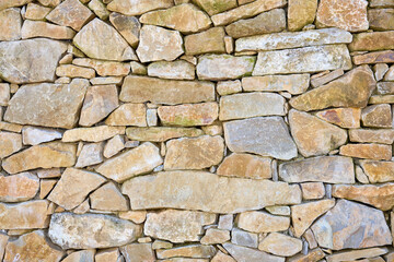 Fototapeta premium Detailed close-up of rustic stone wall featuring various rock shapes and textures