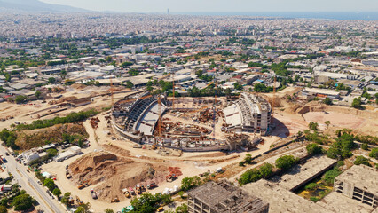 Fototapeta premium Large sports stadium building project underway with cranes and heavy machinery, creating new infrastructure in a densely populated urban area, planning for future facility development