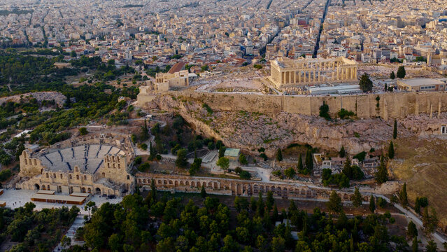 Acropolis complex and the ancient ruins of parthenon and odeon of herodes atticus are rising above the dense urban landscape of athens, representing the historical architecture of greece