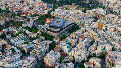 Obraz premium Athens cityscape presenting the modern acropolis museum building surrounded by dense urban residential areas and historic archaeological sites under clear sky