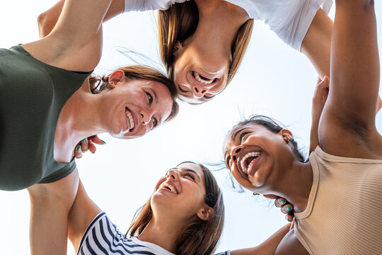 Diverse women forming circle, smiling and laughing together