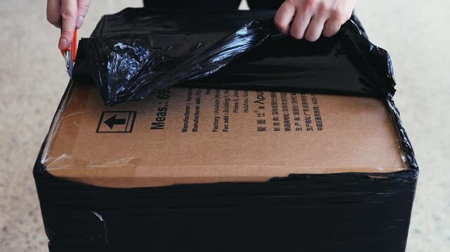 Businessman, man opening big box or cutting with package in warehouse for logistics, return order. Male person, distributor or supplier opening cargo or parcel, courier security distribution