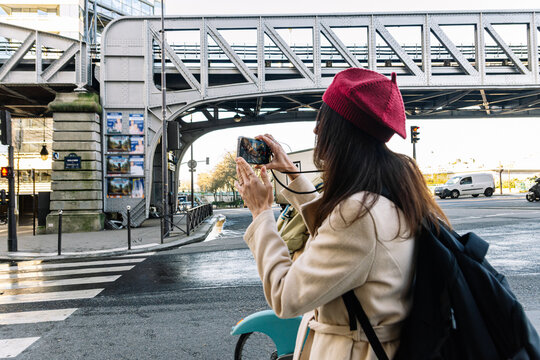 Solo woman traveling in paris taking a picture of bir hakeim bridge
