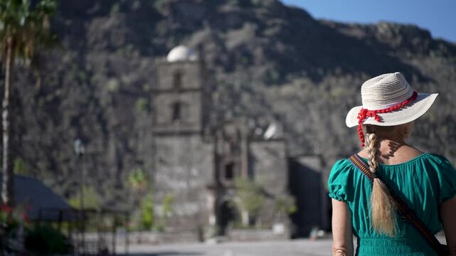 Senior woman smiles and explores the historic San Javier Mission at sunrise in Baja California Sur, Mexico near Loreto