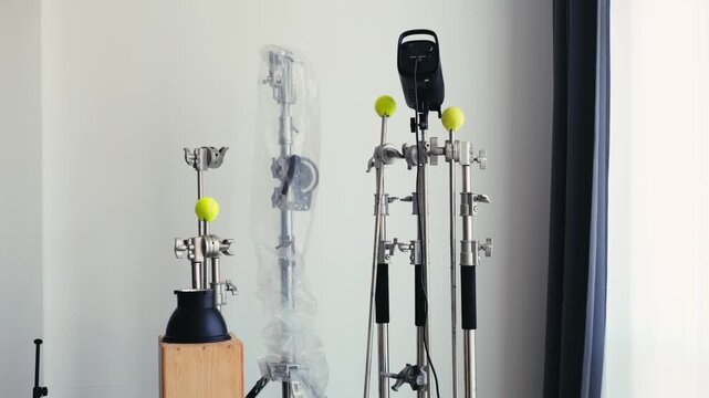 Photo video studio interior with a grey background and professional lighting equipment, backstage with c stands