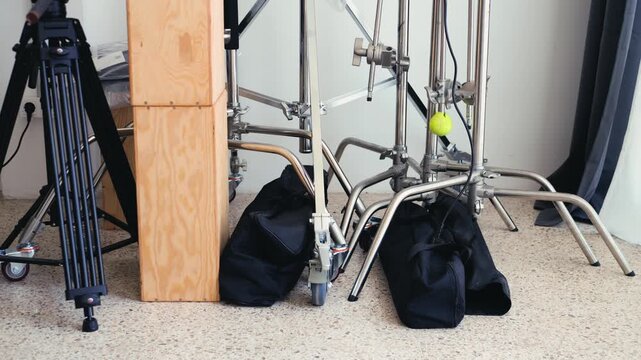 Photo video studio interior with a grey background and professional lighting equipment, backstage with c stands