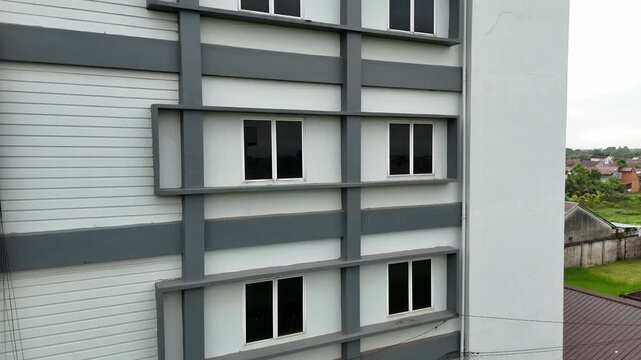 The facade of a modern apartment building with symmetrical windows and a minimalist-style gray exterior.