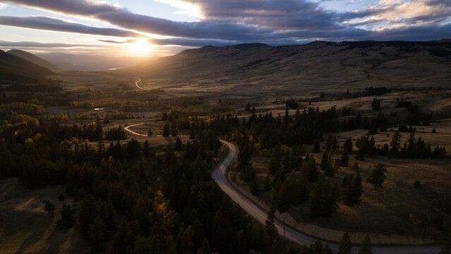 Scenic view of winding road through valley at sunset