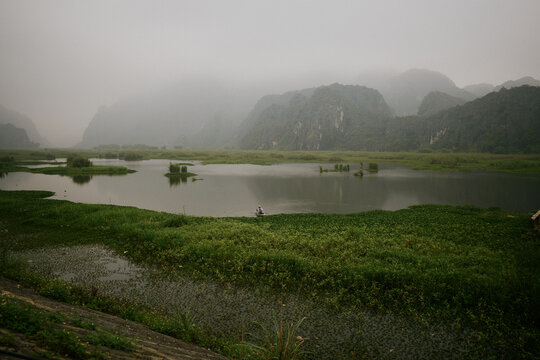 Landscape view of a river with fog and mountains in the background