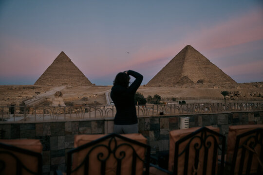 Sunset view of pyramids in Egypt with traveler taking pictures