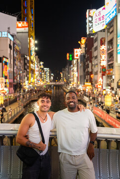 Friends posing for a photo in the vibrant Dotonbori district