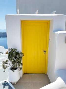 Bright yellow door on whitewashed Greek island building