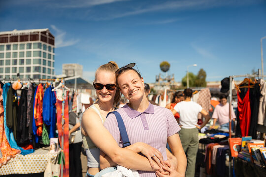 Lesbian couple hugging at flea market