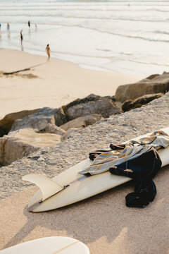 Surfboard and Wetsuit on Shore