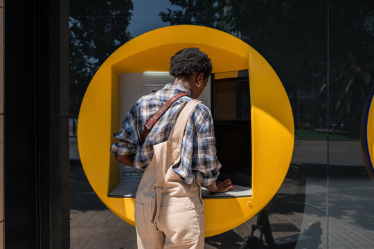 Woman withdrawing cash from bank ATM 