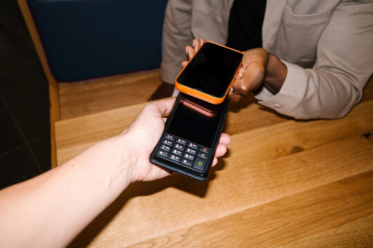 Person paying contactless with smartphone at terminal