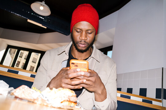 Young man using smartphone while dining