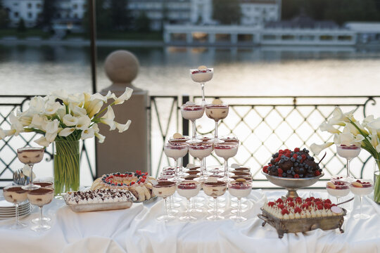 Cropped view of stylish decorated table with flowers and tasty sweets