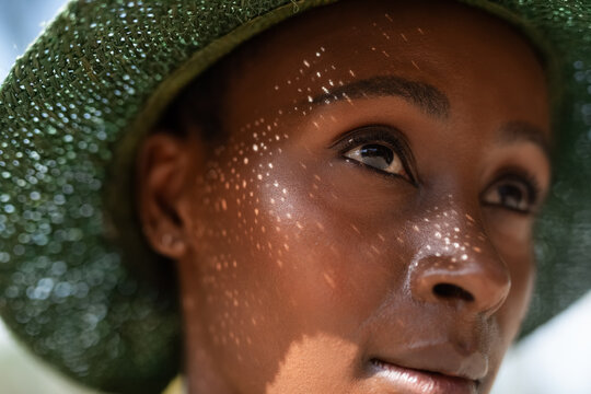 Woman Wearing Green Hat With Sunlight Patterns on Her Face