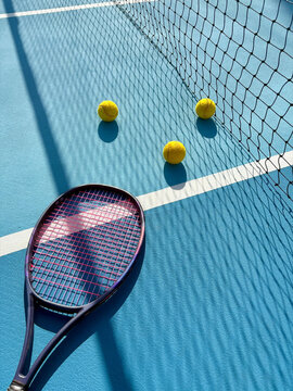 Tennis Racket and Balls on Court
