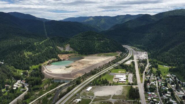 Drone shot showing the mountainous landscape of Osburn Idaho featuring Interstate 90 and forested valley in Saint Joe Mountains