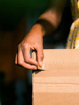 Woman opening box in sunlight 
