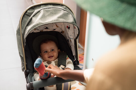 Woman entertaining baby in stroller 