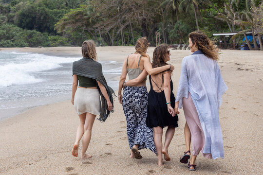 friendship, group of women walk together on the beach