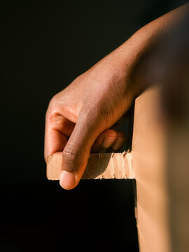 Woman opening cardboard box at home in sunlight 
