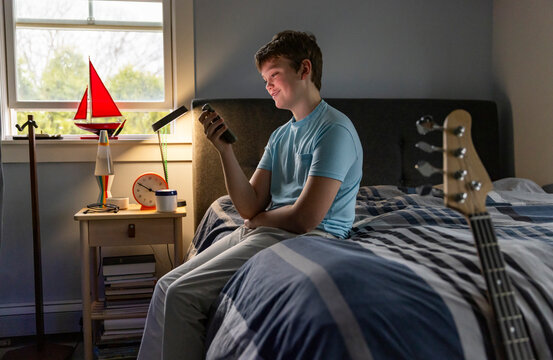 Teenager smile looking at cell phone bedroom 