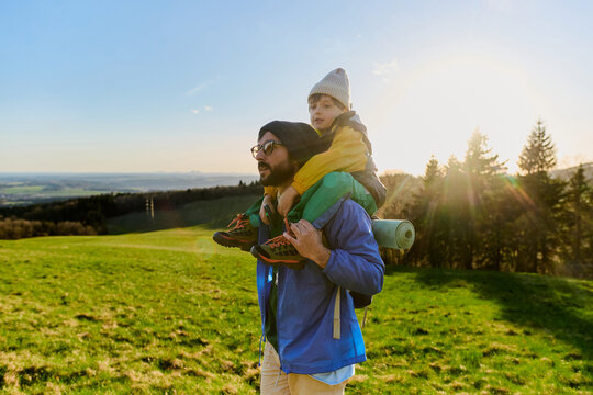 Father carrying child on shoulders in nature