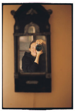 Smiling person takes a picture in a mirror