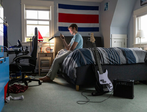 Teenager looking at smartphone bedroom 