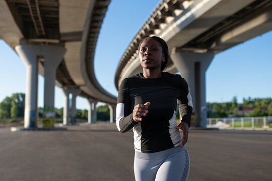 Determined black female athlete running in morning