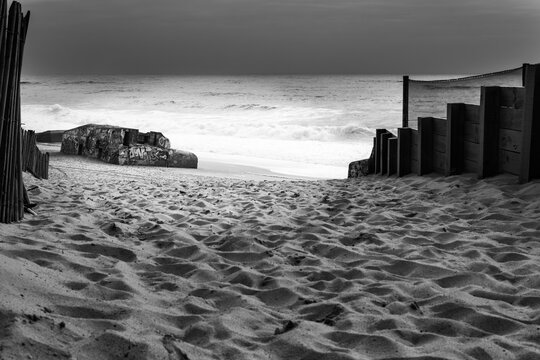 Low key black and white fine art photography of an abandoned WWII graffiti bunker on Labenne beach, France