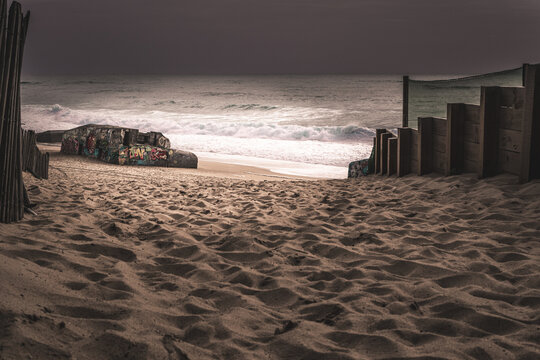 Dramatic purple twilight sky over a WWII graffiti bunker on the stormy ocean beach of Labenne, Landes, France
