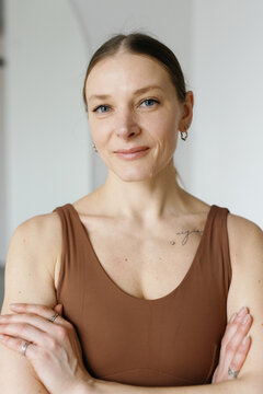 Portrait of cropped sportswoman with crossed arms looking at camera