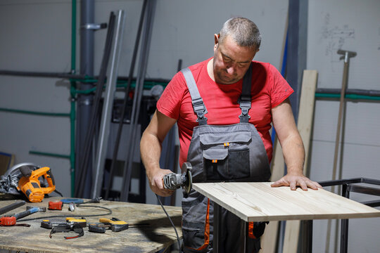 Man sanding plank